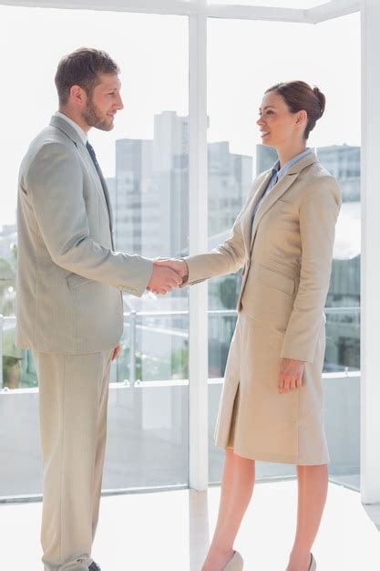 Premium Photo | Business people shaking hands and smiling in a large office