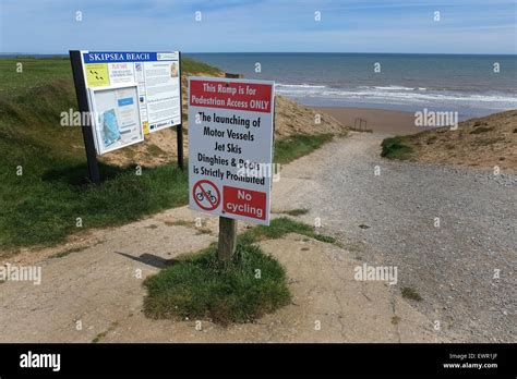 East coast beach with welcome and warning signs Stock Photo - Alamy