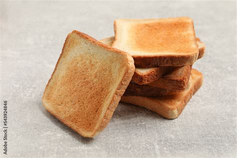 Slices of tasty toasted bread on light grey table Stock Photo | Adobe Stock