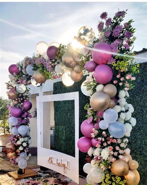 a decorated entrance with balloons and flowers on the outside, in front ...