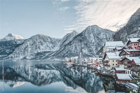 Snowy village Hallstatt by lake at foot of snow mountain with clear sky ...