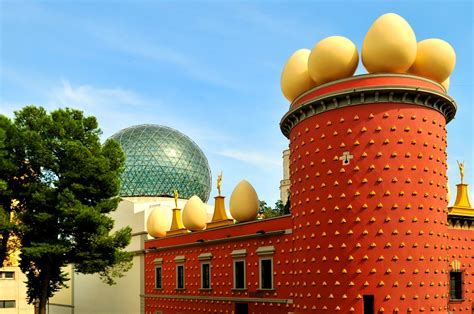 a large red building with yellow eggs on it's roof next to a green dome