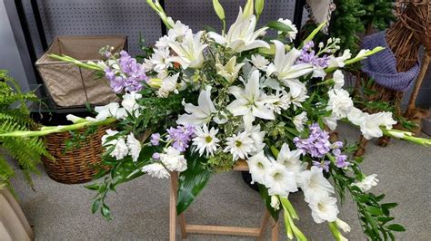 An incredible casket spray with white lilies, purple stock, and more by ...