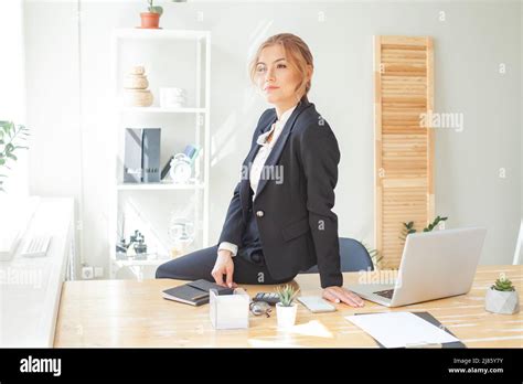 Smiling business woman sitting at her office workstation Stock Photo ...