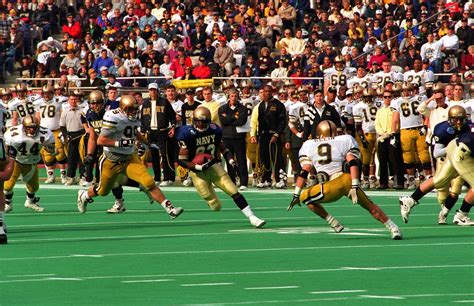 A U.S. Naval Academy football player advances the ball forward during ...