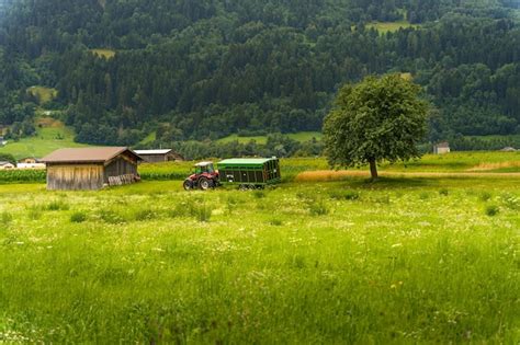 Premium Photo | A tractor parked near the small wooden barn on a farm