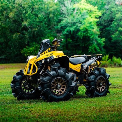 a yellow and black four - wheeler parked in the grass