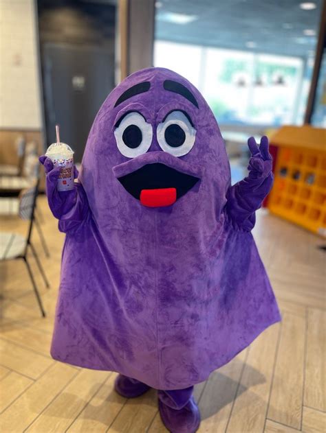 a person in a purple costume holding an ice cream cone