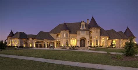 a large house lit up at night with lots of windows and lights on the front