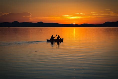 2 Person on Boat Sailing in Clear Water during Sunset · Free Stock Photo