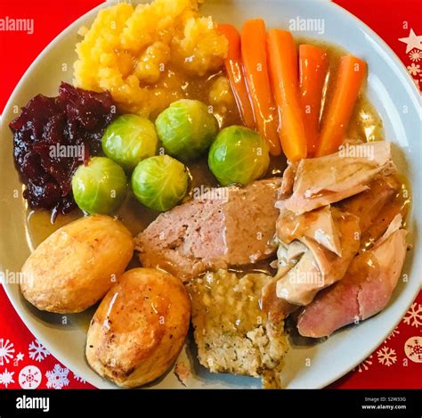 Christmas roast turkey dinner served in a pale plate with a red place ...