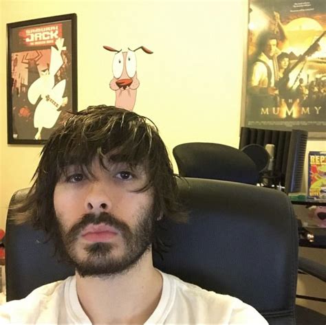 a man with long hair sitting in an office chair