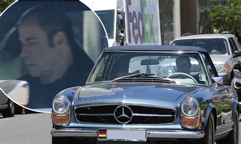 John Travolta takes one of his prized vintage cars out for a spin as he ...