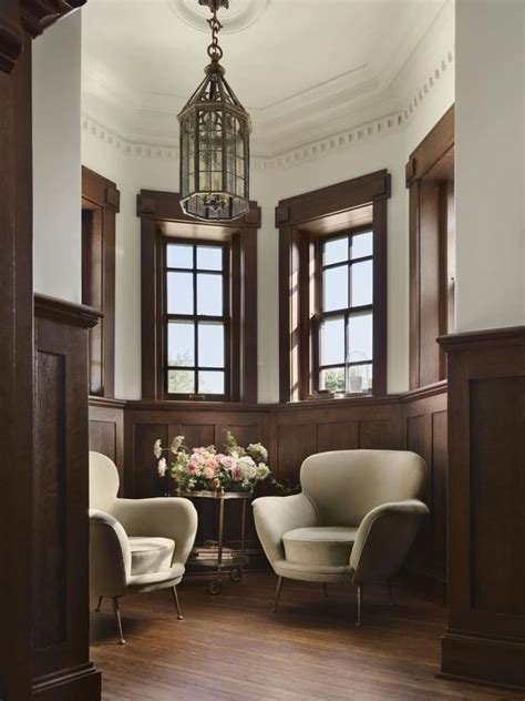 two chairs and a table in a room with wooden paneling on the walls ...