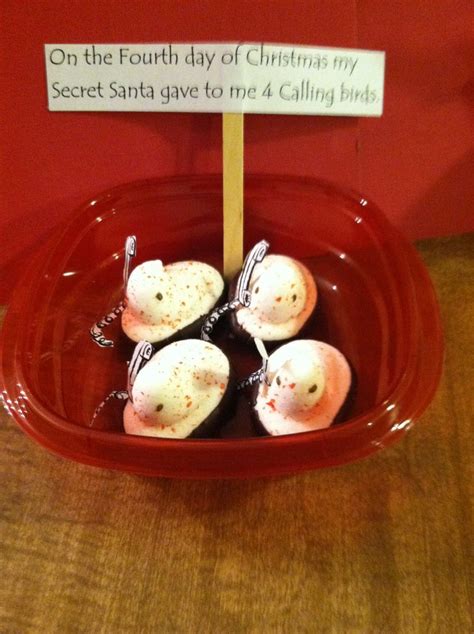 four heart - shaped marshmallows in a red bowl with a sign on it