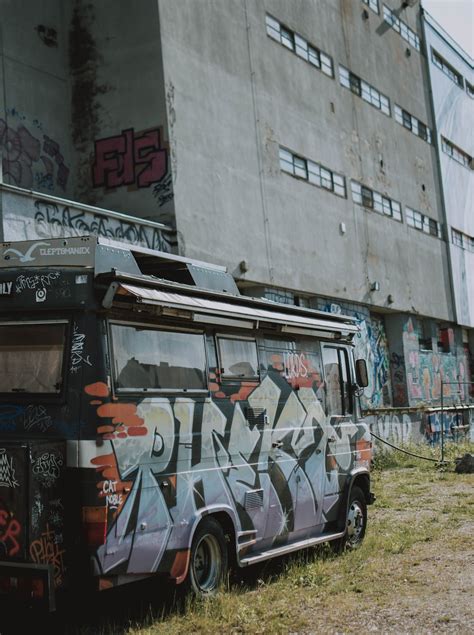 Bus with colorful graffiti near factory · Free Stock Photo