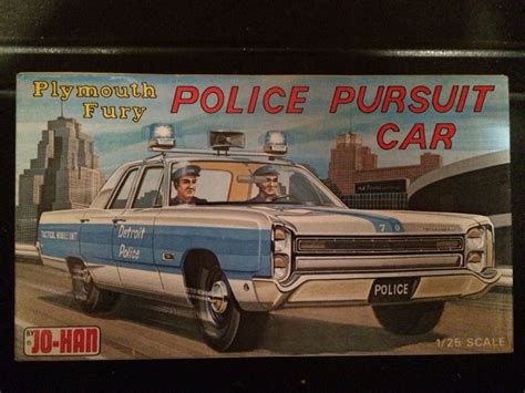 a police pursuit car with two men in the front and one on the back side