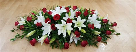 Coffin spray of white lilies and red roses. The classic funeral tribute ...