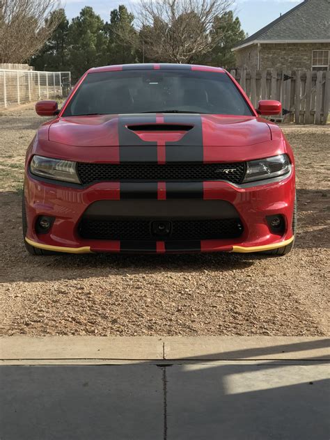 the front end of a red and black dodge charger parked in a driveway ...