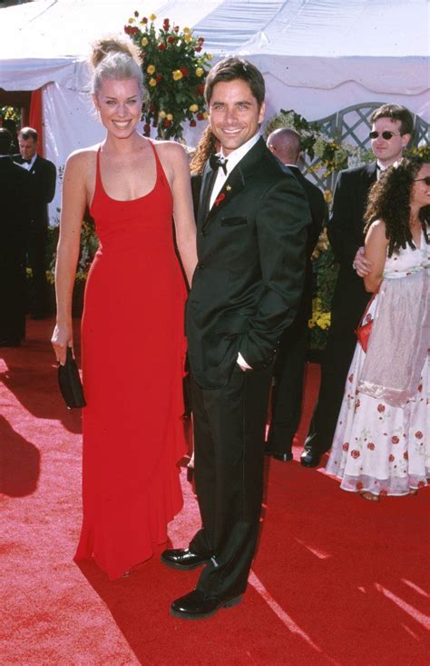 a man and woman in formal wear standing on a red carpet