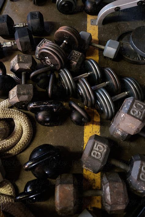 "A Jumble Of Dumbbells And Kettlebells On The Floor Of A Gym" by ...