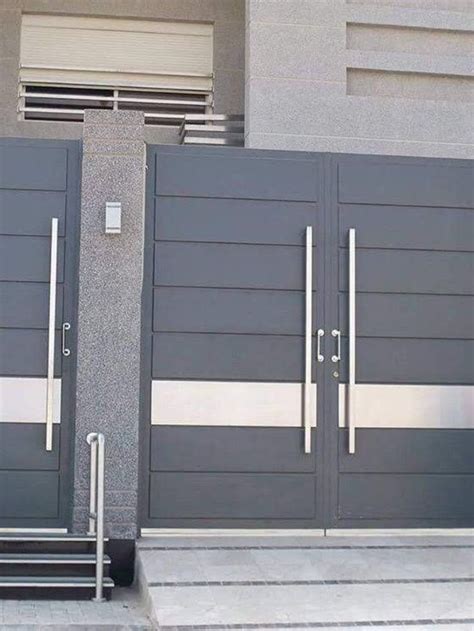 two large gray doors on the side of a building with stairs leading up ...