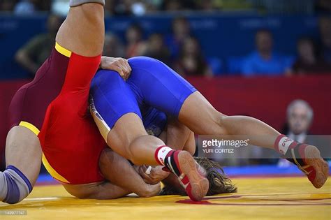 China's Jing Ruixue (L) wrestles Russia's Lubov Volosova in their Women ...