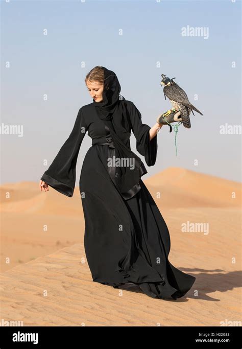 Emirati woman in traditional emirati dress (abaya) with a falcon Stock ...