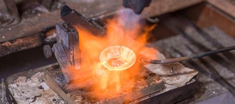 Melting process of precious metal gold behind a jeweler's workbench ...