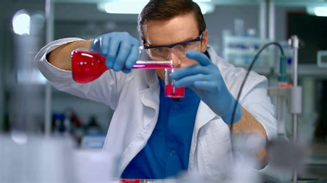 Scientist in lab doing medical research. Laboratory worker pour liquid ...