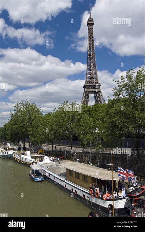 The Eiffel Tower (La Tour Eiffel) stands over boats moored on the Seine ...