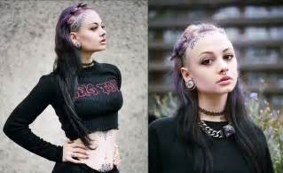 a woman with purple hair and piercings on her head is wearing a black top