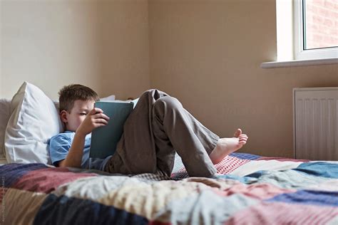 "Boy Reading A Book While Lying On A Bed" by Stocksy Contributor ...