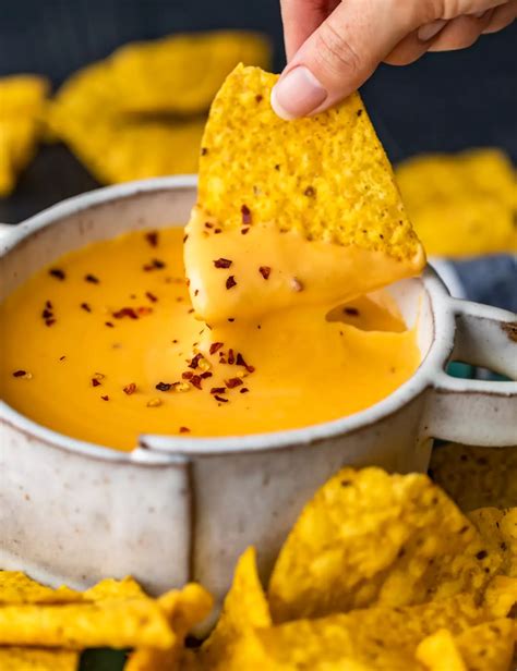 dipping a tortilla chip into a bowl of nacho cheese sauce | Cheese ...