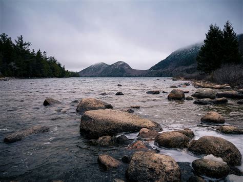 Wild rocky river flowing in mountainous terrain against foggy sky ...