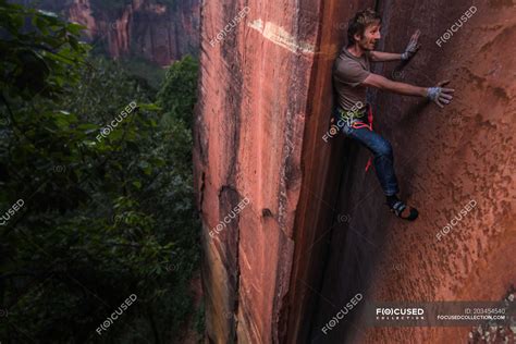 Rock climber climbing sandstone rock, elevated view, Liming, Yunnan ...