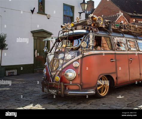 A customised Volkswagen camper van travelling on a cobbled road ...