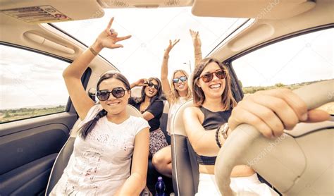 Four girls driving in a convertible car and having fun Stock Photo by ...