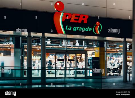 Iper logo and showcase of the store at night. Iper is the brand with ...