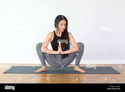 Beautiful woman doing a yoga pose called squat pose, or malasana Stock ...