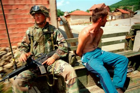 U.S. Marines escort a villager arrested for looting in Zegra, Kosovo.