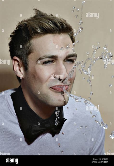 Young man spitting out water Stock Photo - Alamy