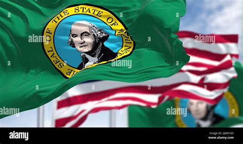 The Washington state flag waving along with the national flag of the ...