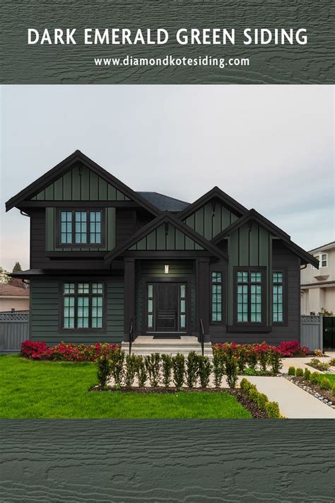 a house with dark green siding and flowers in the front yard