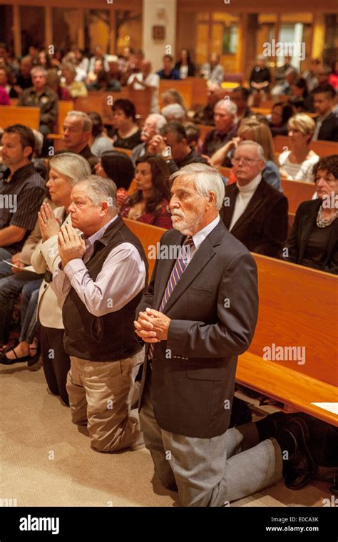 The congregation kneels in prayer during mass at St. Timothy's Catholic ...