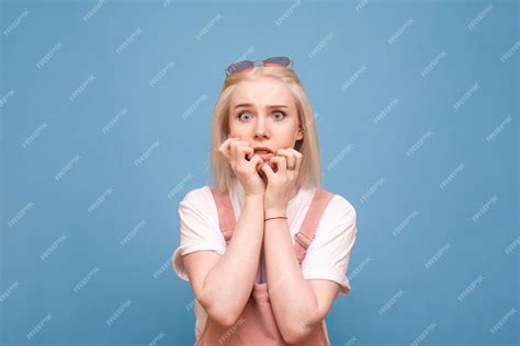 Premium Photo | Portrait of a frightened girl on a blue background ...