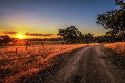 Countryside landscape with rural dirt road at sunset in Australia ...