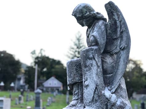 Premium Photo | A sad angel statue in a graveyard