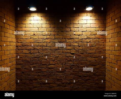 abstract old brick wall in the dark with two spotlight, warm light tone ...