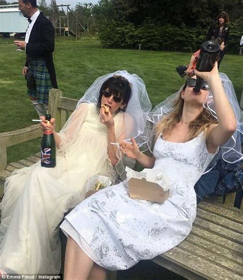 two brides are sitting on a bench and one is eating